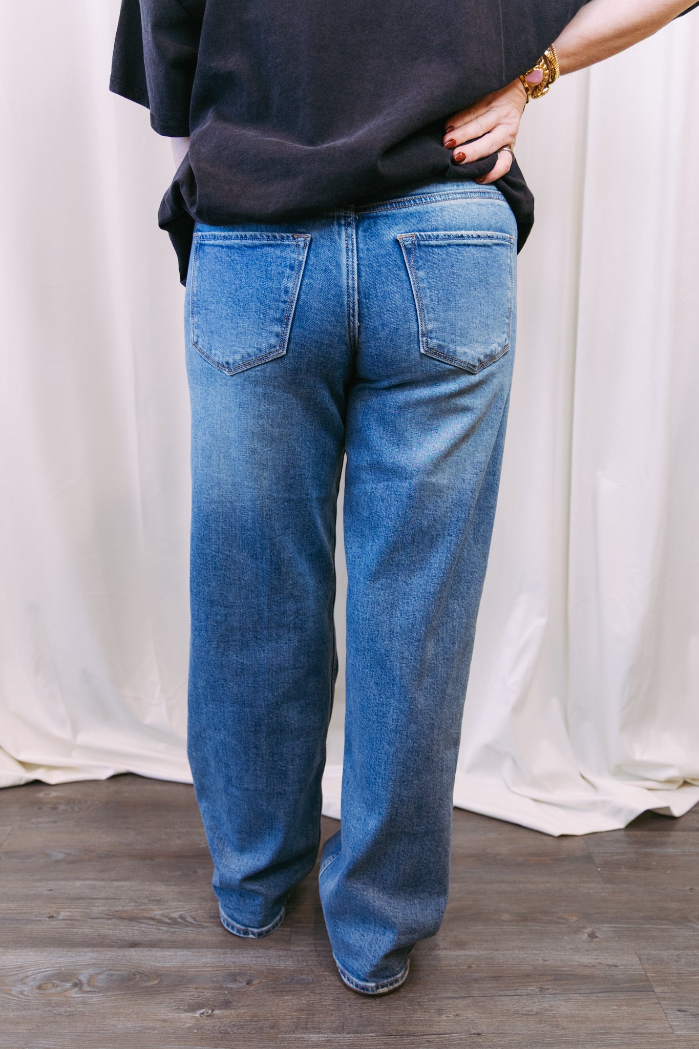 Person wearing blue jeans with a plain background