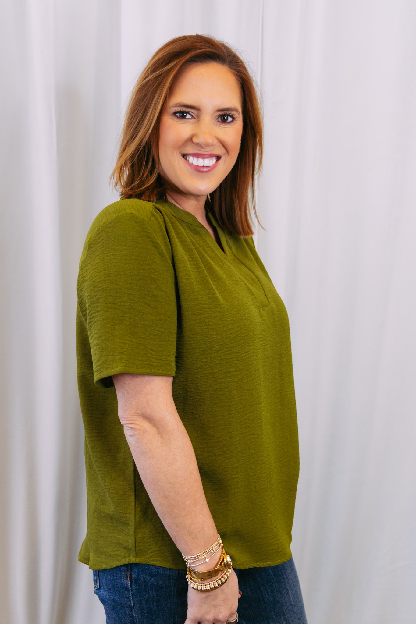 Woman wearing a green shirt against a white background