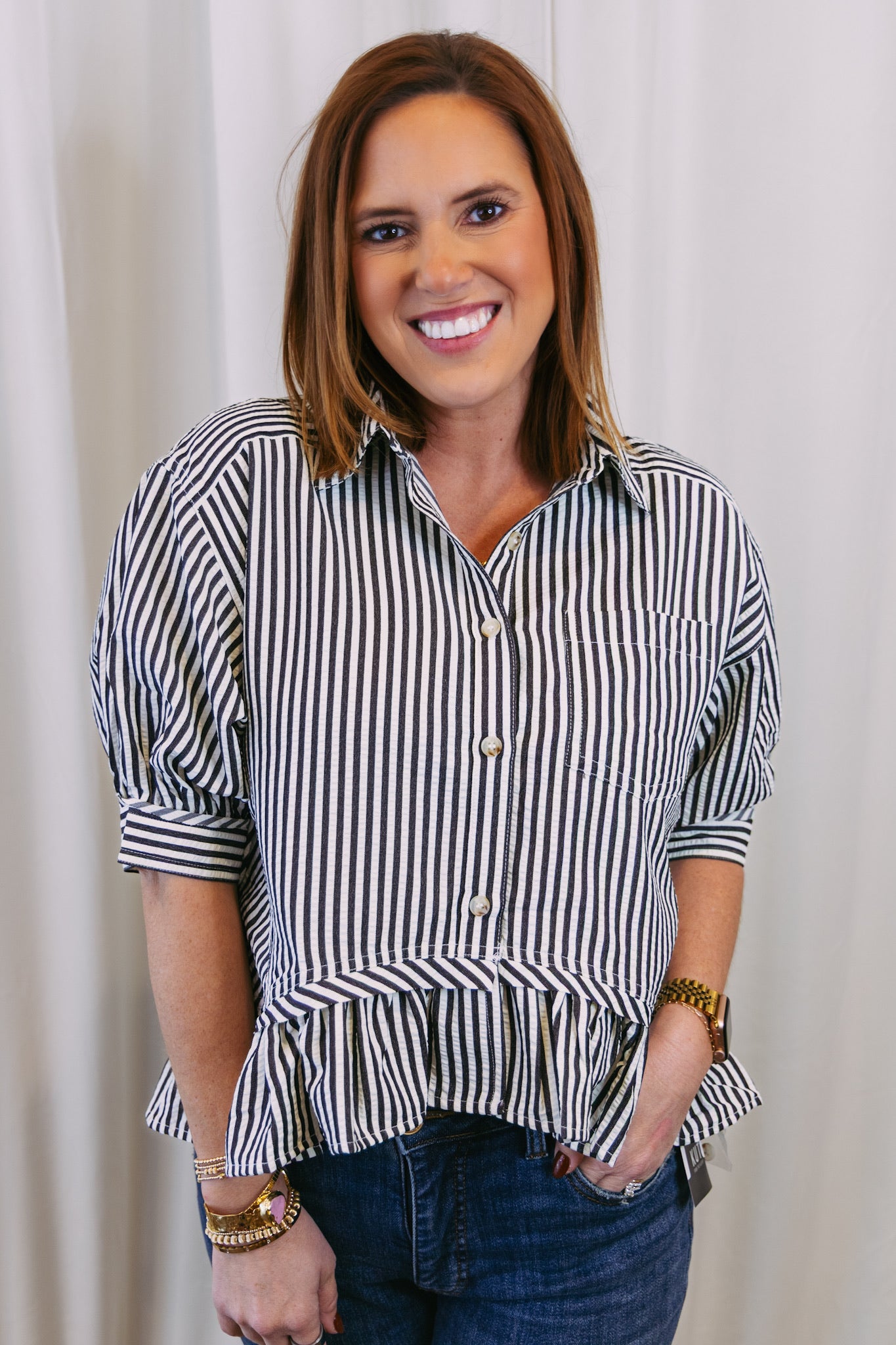 Woman wearing a black and white striped shirt against a plain background